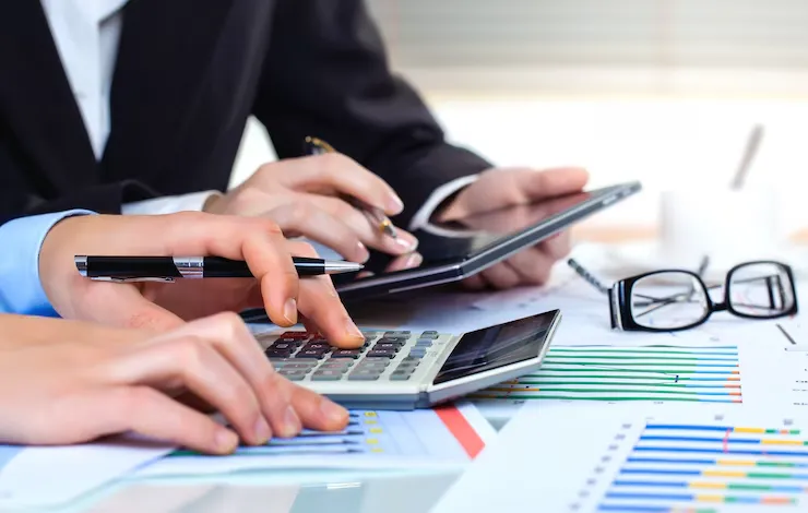 Vista superior de manos tomando notas durante asesoría.